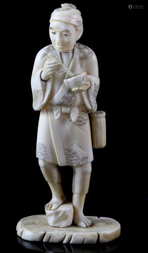 Late 19th/early 20th century Japanese ivory okimono of a man standing eating with chopsticks,