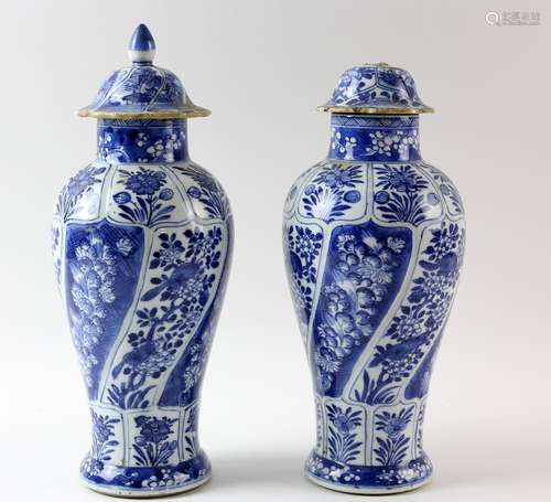 Pair of Chinese blue and white baluster vases and covers with panels of floral decoration, on