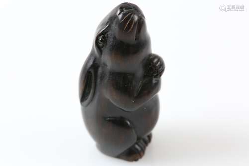 Early 20th century Japanese carved hardwood netsuke of a hare gazing up at the moon, signed on round