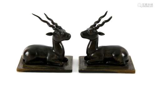 Pair of early 20th century Rhino horn carvings of recumbent antelope, on rectangular horn (