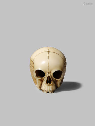 A JAPANESE IVORY NETSUKE MEIJI 1868-1912 Depicting a human skull, with details realistically