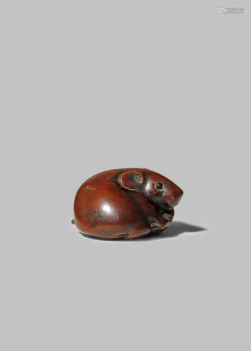 A JAPANESE WOOD NETSUKE OF A RAT EDO/MEIJI PERIOD The chubby rodent depicted lying and tenderly