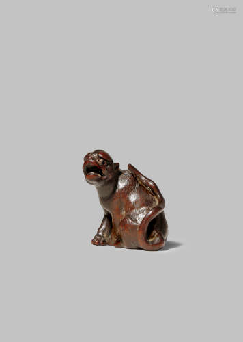 A JAPANESE WOOD NETSUKE OF A TIGER EDO/MEIJI PERIOD The feline seated on its haunches, with the head
