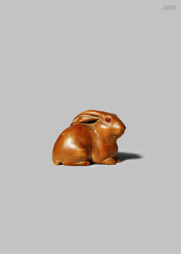 A JAPANESE WOOD NETSUKE 19TH/20TH CENTURY Carved as a rabbit, the small mammal resting on a reishi
