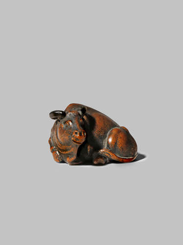 A JAPANESE WOOD NETSUKE EDO/MEIJI PERIOD Depicting a large ox reclining, its legs neatly tucked