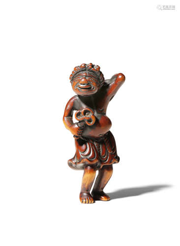 A JAPANESE WOOD NETSUKE EDO 1603-1868 Depicting a standing South Sea Islander, holding a shakujo