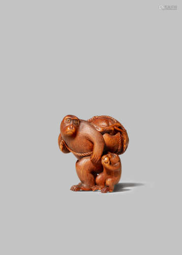 A JAPANESE WOOD NETSUKE MEIJI 1868-1912 Depicting a monkey with its young and carrying a giant peach