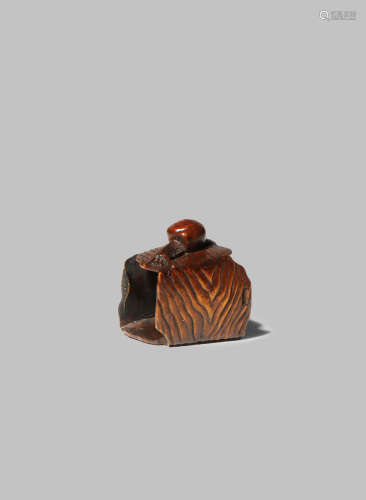 A JAPANESE WOOD NETSUKE MEIJI 1868-1912 Carved as a snail slithering over the top of a discarded