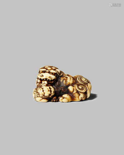 A JAPANESE IVORY NETSUKE EDO 1603-1868 Carved as a large shishi lying against her pup, the