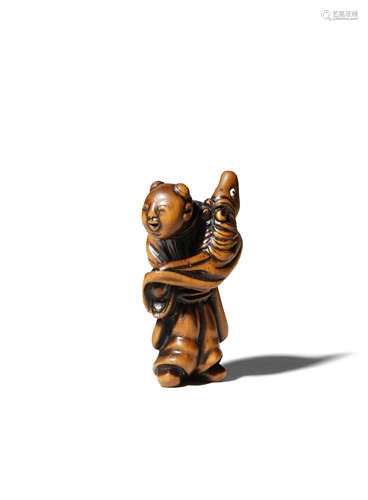 A JAPANESE WOOD NETSUKE EDO 1603-1868 Depicting a small karako holding a hobby horse, the boy