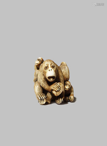 A JAPANESE IVORY NETSUKE EDO/MEIJI PERIOD Depicting a monkey holding a large chestnut, with three