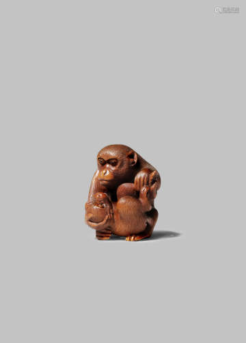 A JAPANESE WOOD NETSUKE MEIJI 1868-1912 Carved as a monkey tenderly holding her young before her,
