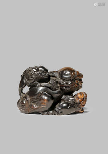 A JAPANESE EBONY CARVING, OKIMONO EDO 1603-1868 Finely carved as a shishi with her two pups,