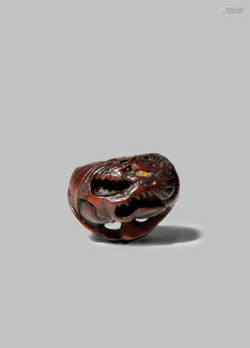 A GOOD JAPANESE WOOD NETSUKE EDO 1603-1868 Carved as a dragon emerging from a large orange, mikan,