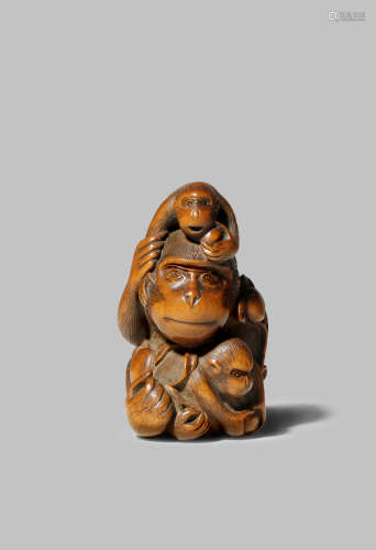 A JAPANESE WOOD NETSUKE EDO 1603-1868 Depicting a large monkey seated with her two young, tenderly