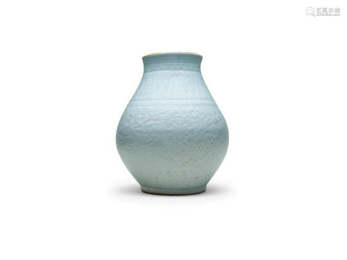 Qing dynasty A celadon glazed carved and moulded 'Buddhist Emblem' jar