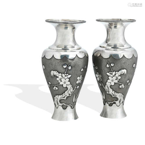 Late 19th/early 20th century A mirrored pair of repoussé decorated silver vases