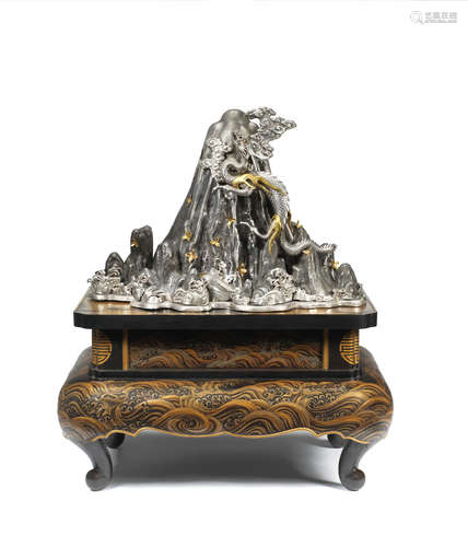 Meiji era (1868-1912), late 19th century, circa 1890s A large and unusual silver, shibuich and gilt okimono of a Dragon ascending Mount Fuji