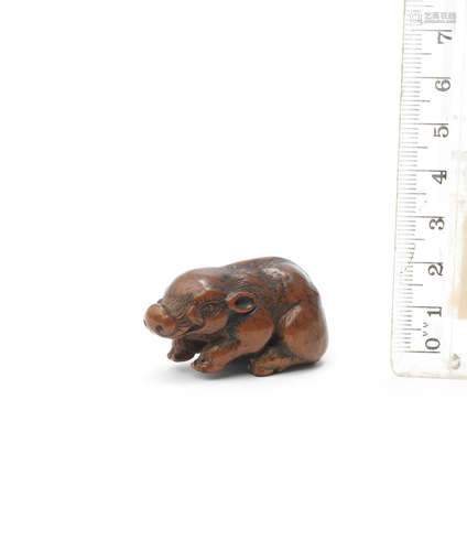 By Juntoku Minko (1735-1816), Edo period (1615-1868), late 18th century A boxwood netsuke of a recumbent boar