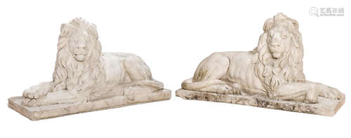 A pair of Continental Baroque style cast stone models of recumbent lions