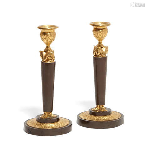 Early 20th century A pair of Empire style gilt and patinated bronze candlesticks