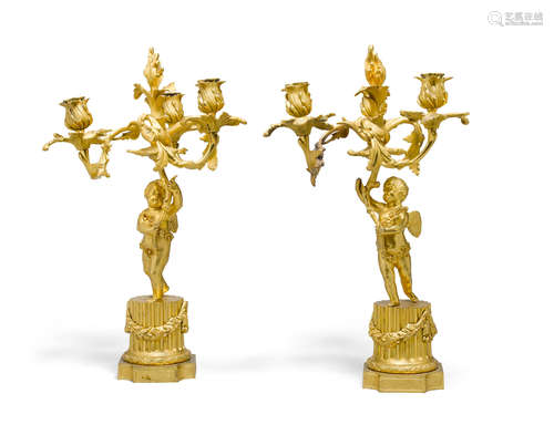 A pair of Louis XVI style gilt bronze figural three light candelabra