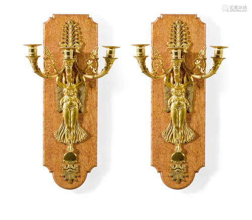 A pair of Empire style gilt bronze and birchwood three light wall sconces