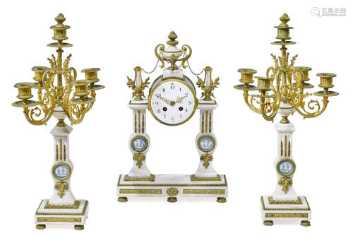 Early 20th century A French gilt bronze mounted marble three piece clock garniture inset with blue jasper medallions