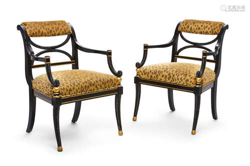 A pair of Regency style parcel gilt ebonized open armchairs