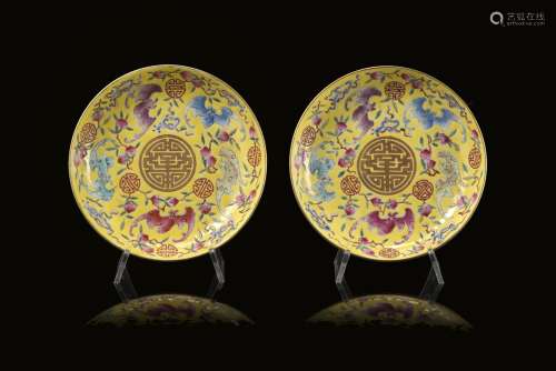 A pair of yellow-ground Famille Rose saucers, each decorated with bats, peaches and auspicious