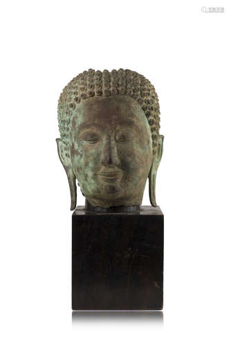 A bronze head of a Buddhist deity, wood base (defects)China, Ming dynasty (1368-1644)(h. 25 cm.)