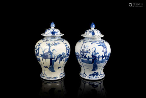 A pair of blue and white potiches and covers decorated with ladies, the bases with Kangxi underglaze