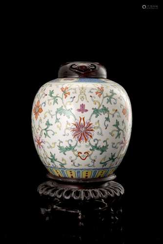 A polychrome-decorated potiche decorated with floral motifs, with carved wood cover and baseChina,