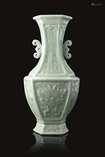 A hexagonal celadon-glazed baluster vase with twin elephant heads handles, decorated in high relief,