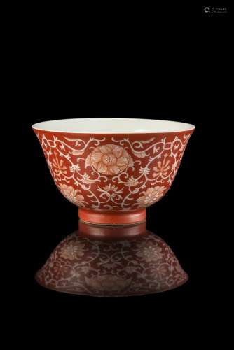 A small coral red cup decorated with floral motifs in reserve with an iron red shen de tang zhi mark
