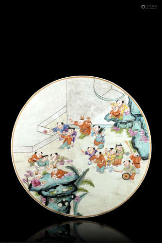 A Famille Rose porcelain plaque decorated with boys at play in a fenced garden (defects)China,