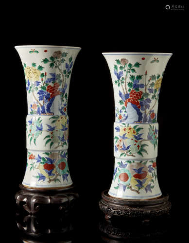 A pair of wucai gu vases, each decorated with auspicious fruits and floral motifs, with wood base (