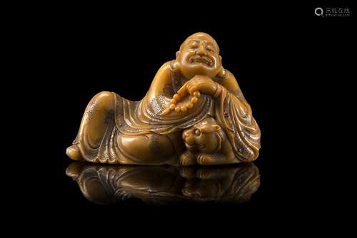 A soapstone model of a luohan in half-seated position, accompanied by a tigerChina, 19th/20th