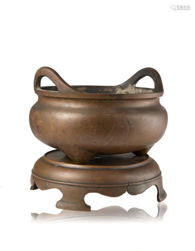 A bronze tripod censer, with twin handles, wood base (slight defects)China, Ming dynasty (1368-