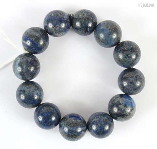 GRAY-BLUE HARDSTONE BEAD BRACELET - Twelve highly polished 2 cm round beads of a blue-gray softly mottled hardstone are strung on a ...