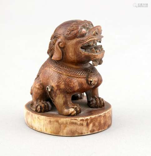 A Chinese Foo-dog signet, 2nd half 19th c., mammoth ivory, oval center with traces of dark colour, coral eyes (lacking one eye), h. 8 cm, d. signet ca. 6 cm