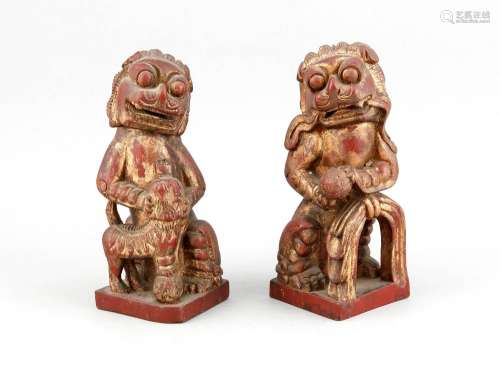 Paar Foo-Löwen, China, 1. V. 20. Jh., Holz geschnitzt, dunkelrote Farbe mit Resten von Vergoldung, H. 26 cm
