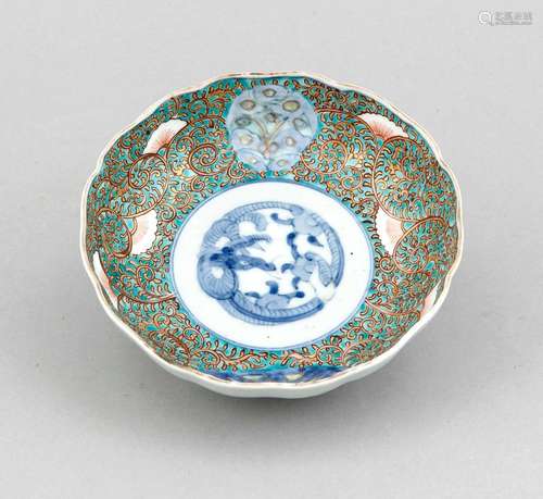 A small lotus-shaped Chinese bowl, 19th/20th c., with scalloped border, raised stand ring, the center with dragon in underglaze blue surrounded by tendril decor in gilt and iron red on turquoise ground, d. 15 cm