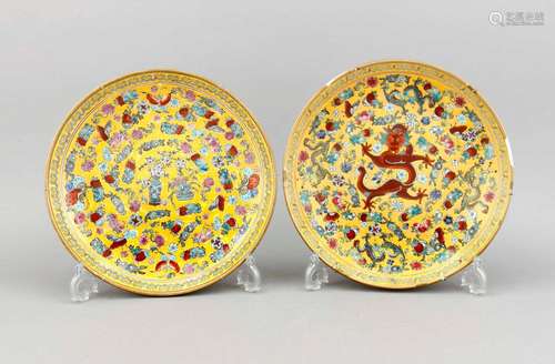 A pair of Chinese plates, 1st quarter 20th c., one plate center with dragon, the other with flowers, butterflies and small dragons, yellow ground, the boder enriched in gilt (rubbed in places), red stamp mark, wire suspension, d. 30 cm