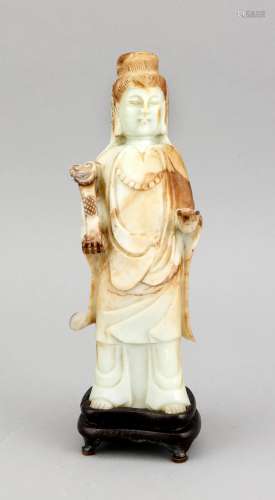 Guanyin-Figur, China, 19. Jh., hellgrün-milchige Jade mit braunen Einschlüssen, eine Hand hält ein Zepter, die andere macht eine Geste, auf 4-füßigem, profiliertem Holzsockel, H. 30 cm