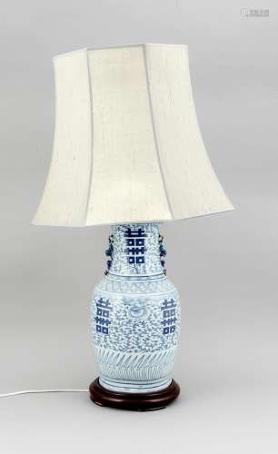 A 19th-century Chinese blue and white vase mounted as lamp, the body painted cobalt blue with symbols of luck and filigree tendrils, animal handles (female foo dog with puppy?), the octagonal lampshade with cream fabric, four-feet wood pedestal, vase h. 45cm