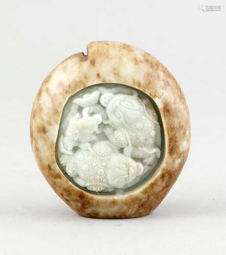 A Chinese jade carving, 19th c., seladon-coloured jade with cloudy brown inclusions, of flattened form, two cut Jin Chan depictions in central medaillon, the medaillon edge softly chipped in places, 9 x 8.4 x 3.8 cm