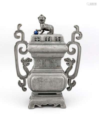 A Chinese pewter censer, presubably 20th c., the rectangular, profiled body with characters in relief, dragon handles in archaic form (softly dented into the bottom body), the open-work cover with foo-dog finial, the paw on a blue glass(?) peral, 4-feet stand, the handles soldered, h. 46 cm