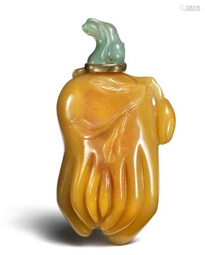 A Chinese yellow jasper snuff bottle in the shape of Buddha's hand (Fou Shou), jade stopper carved in the shape of a stalk in a metal setting. Qing. H. 7 cm.