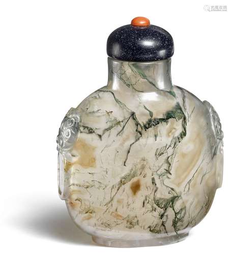 A Chinese moss agate snuff bottle, sides carved with mask and handles. Qing 19th century. H. 6 cm.